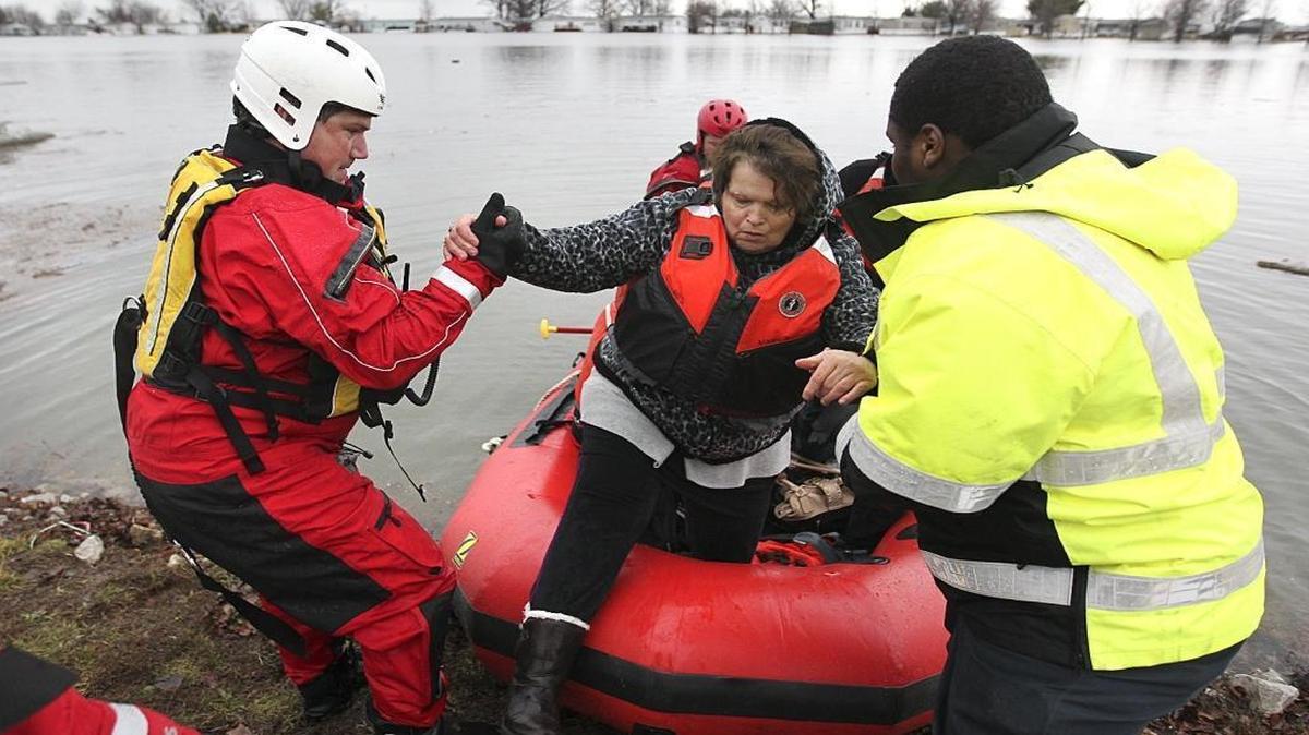 Mallard Lake subdivision resident Kathy Simmering gets assistance getting off a boat during December. Her subdivision in Pontoon Beach was flooded in December.