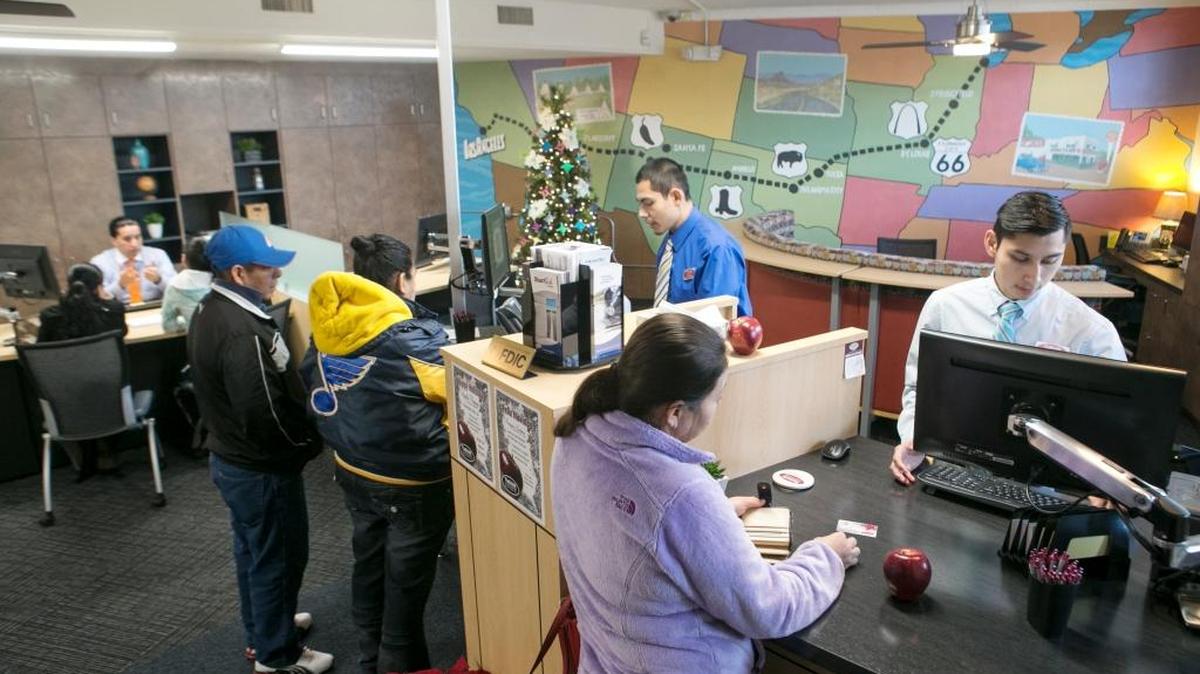 The Bank of Edwardsville has opened a bilinqual banking center in Fairmount City. The bank is located at 2870 North 44th St. inside the same building as the library. Left to right universal banker Eric Herrera can help customers with new accounts, loans and other banking questions and tellers Victor Ortiz and Jorge Medina process regular banking transactions. On December 24 the bank continued a 53 year tradition of passing out apples to their customers.