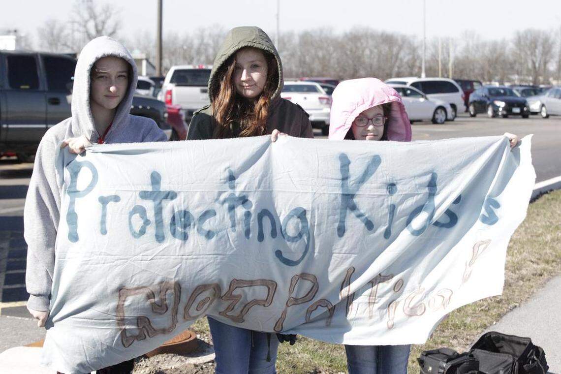 Three Highland Middle School students, escorted by their parents, walked across the street to participate in the walkout at Highland High School on Wednesday morning. Pictured from left: seventh-grader Joanna Fogg, seventh-grader Grace Powers, and sixth-grader Hillary McLaughlin. They made a sign that read "Protecting Kids is Not Political."