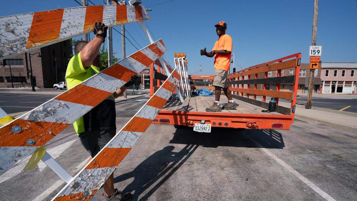 Workers with Warning Lites of Southern Illinois LLC take down barriers along North High Street leading to the Belleville Public Square on Friday. The square has been blocked off for three months due to a construction project.