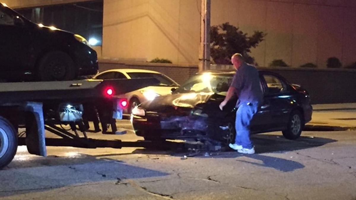 A tow truck driver prepares to haul away a car involved in a crash at the intersection of Illinois and Washington streets in downtown Belleville Saturday night. One driver was injured and another motorist was arrested.