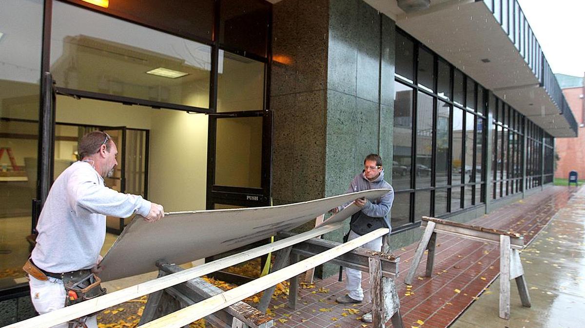 Robert Hoef, left, and Andy Siebert lift some concrete board they just cut as part of the construction at the building at 222 E. Main St. Monday in Belleville.