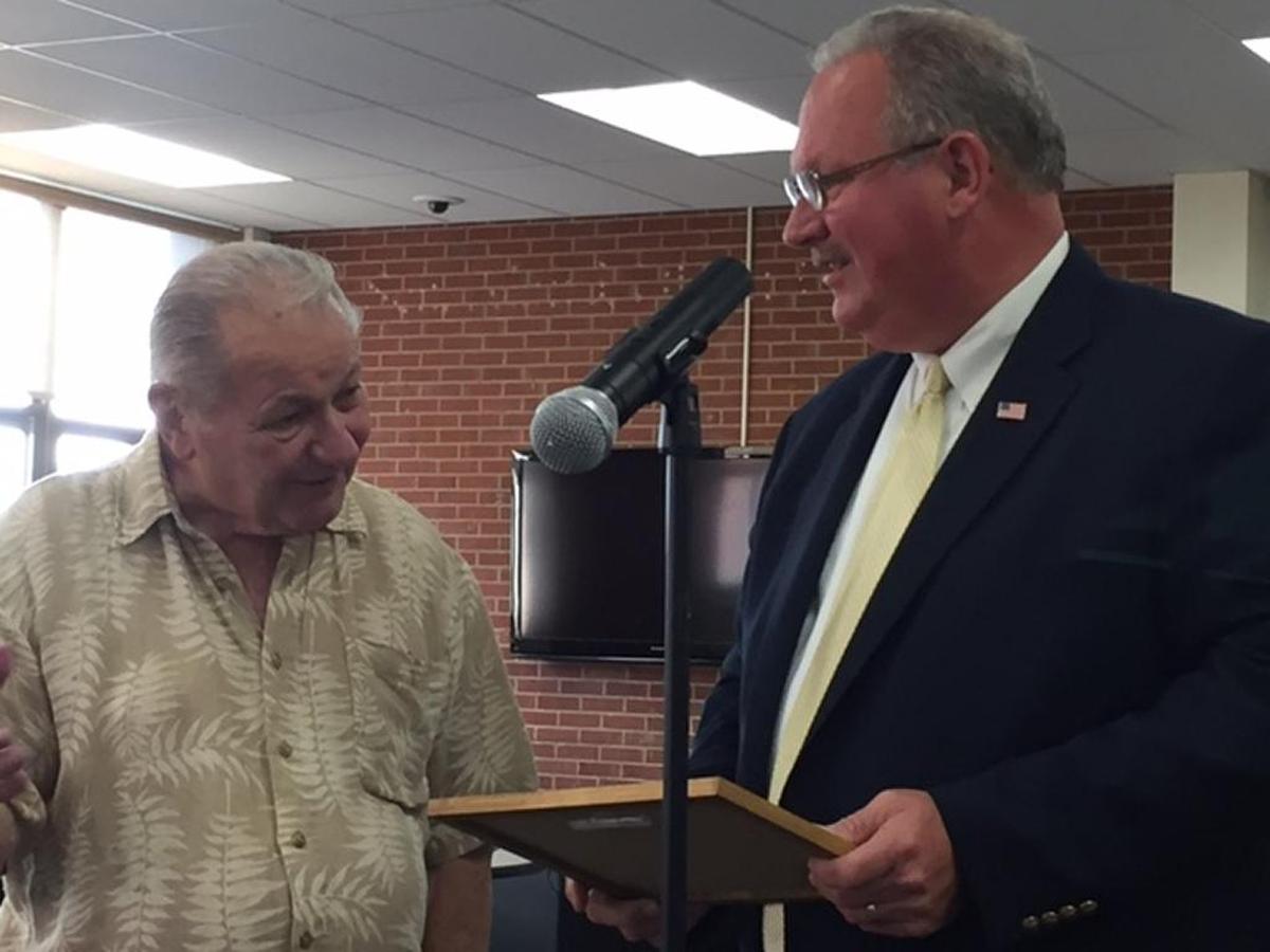 Bob Kaiser, left, was honored by Belleville Mayor Mark Eckert and the City Council on Monday night for operating Bob’s Barber Shop at 2117 W. Main St. for 50 years.