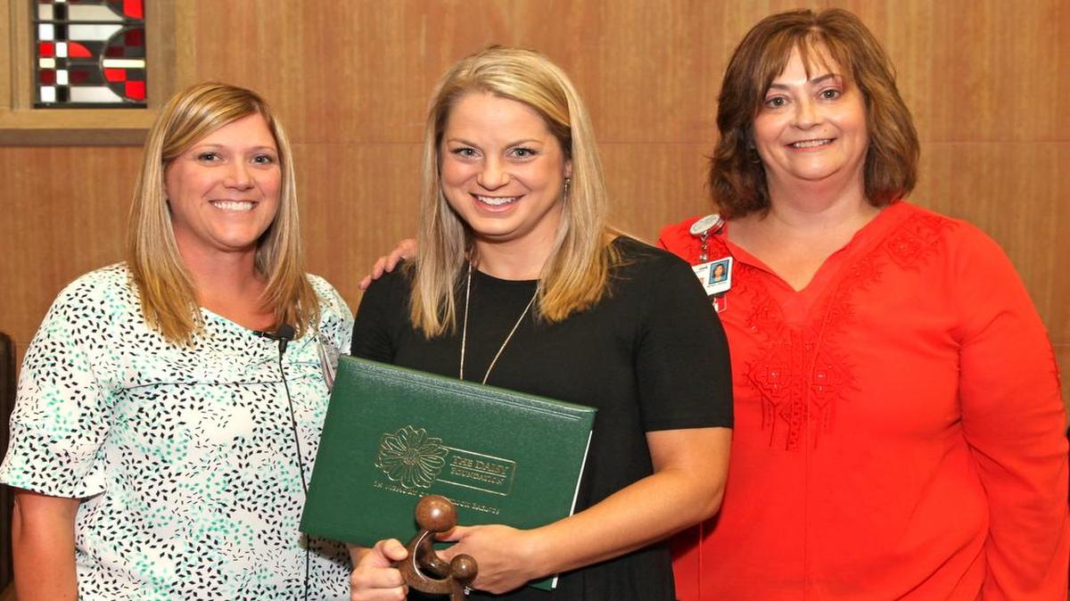 HSHS St. Elizabeth’s Hospital interim chief nursing officer Carrie Erlinger, along with Regina Peterson, nurse manager of staff development, award Sarah Winet of Highland (center), a registered nurse with the St. Elizabeth’s Mother Child Center, with the National DAISY Award for Extraordinary Nurses.