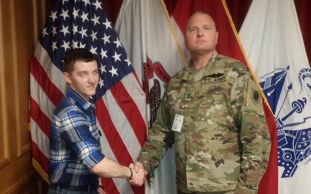 Spc. James Smith of New Douglas shakes hands with Sgt. 1st Class Thomas Reif, a recruiter with Illinois National Guard at the St. Louis Military Enlistment Processing Station.