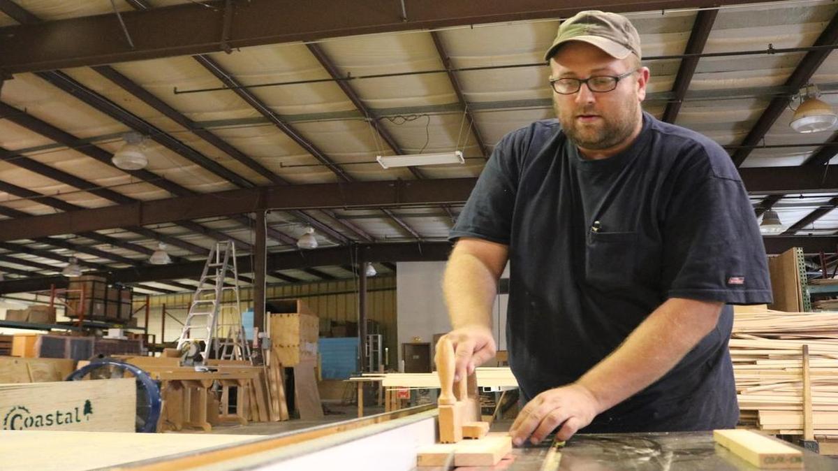 Cory Wright, an employee of Wicks Organ Co., cuts wood on a table saw in the new Wicks facility located at 416 Pine St. in Highland.