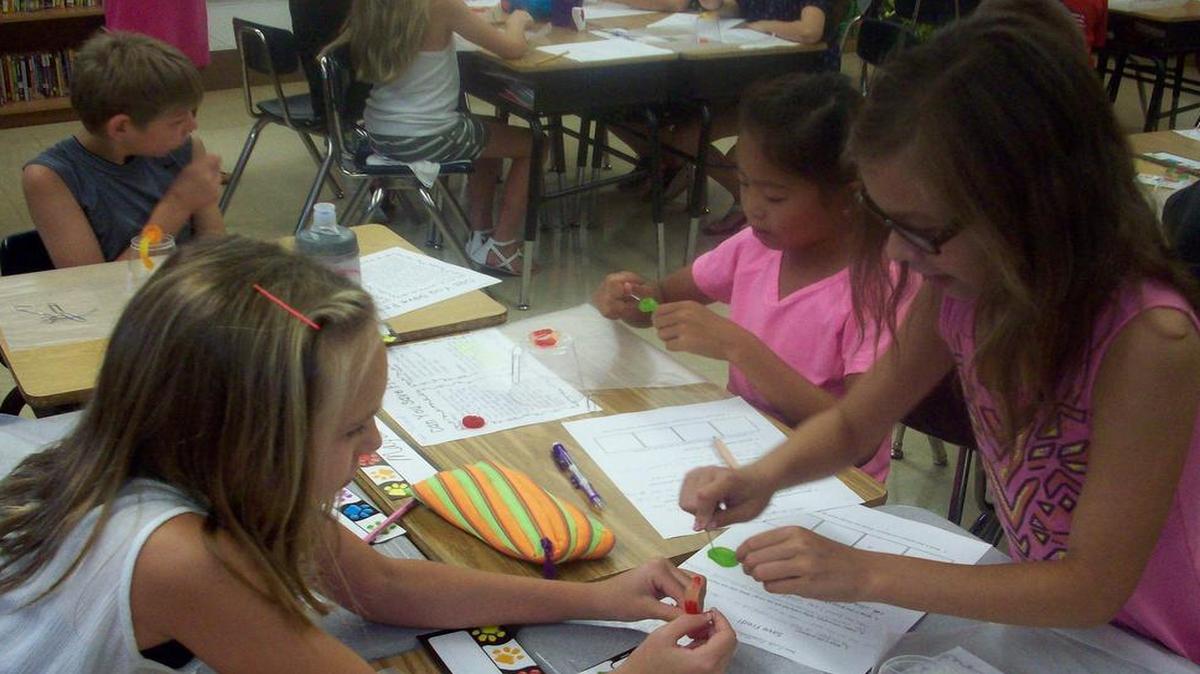 
Ellie Hughes, left, helps Ava Griffith-Lercher, fourth-graders in Mrs. Langham’s class at Highland Elementary, save “Fred the Worm.” Also pictured, Maya Pollard works on her own Fred. Saving Fred is an edible team-building STEM (science, technology, engineering and mathematics)activity with students using the Scientific Method. Fred, a not-so-smart gummy worm, cannot swim. His boat (a plastic cup) has capsized and his life jacket (a gummy lifesaver) is under the boat. Students must work to save Fred using only paper clips.
