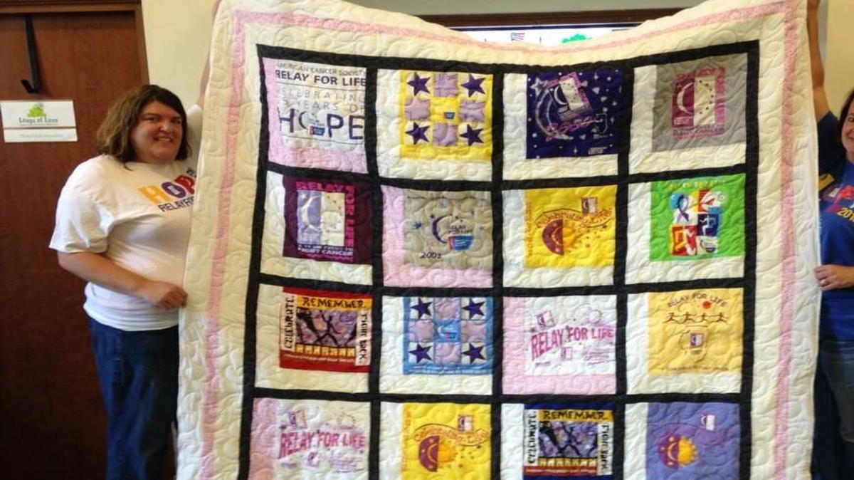 
Joy Krouper, event leader for Highland’s upcoming Relay for Life, and Julie Hanna, logistics co-chair for the Relay, hold up a colorful quilt made from T-shirts from previous Relays. The quilt will be on display at the Peanut Butter & Jam Festival on Friday, June 19. 

