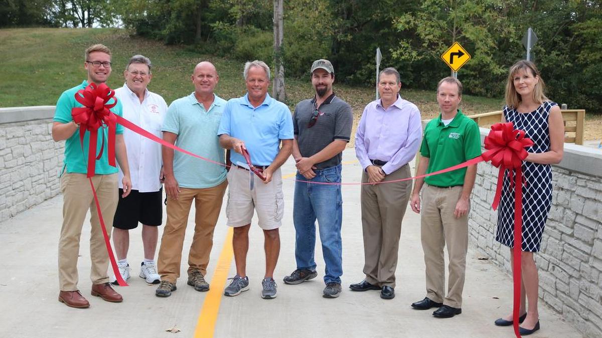 From left to right: Sean Maher, city intern, Mayor Joe Michaelis, Director of Parks and Recreation Mark Rosen, Helvetia Sharpshooters Society Presdent Gary Bargetzi, Project Manager and Resident Engineer for the city Clint Conrad, City Manager Mark Latham, Metro East Park & Recreation District Executive Director Bryan Werner, who assisted the city with achieving a grant for the trail and Assistant City Manager Lisa Peck at the ribbon cutting for the Sharpshooters Trail on Oct. 3. The trail now links the east side of the city from Coventry Way, with a paved path and bridge over Lindenthal Creek. The trail then heads up Park Hill Drive to Lindethal Avenue by the Highland Primary School.