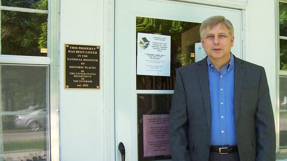 Roy Anderson stands next to the marker on the Marine Library indicated the building’s presence on the National Register of Historic Places by the United State Department of the Interior.