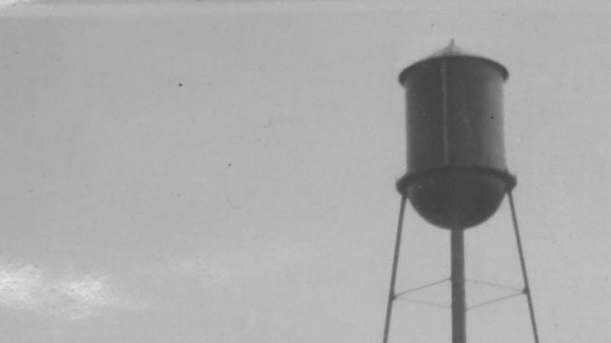 
This photo shows the old concrete reservoir and the 1929 elevated steel water tower. Bruno Bargetzi, the city’s former water superintendent wrote this on the back of the photo: “This is our new standpipe where I pump the water in and the city gets it out of there by gravity. That four-cornered building you see on the side of it is the old water tank, which we don’t use anymore. The new tank is 109 feet high. How would like to crawl up there? I have to go up there once a week... It is 75 feet to where the catwalk is. It hold 100,000 gallons of water.”

