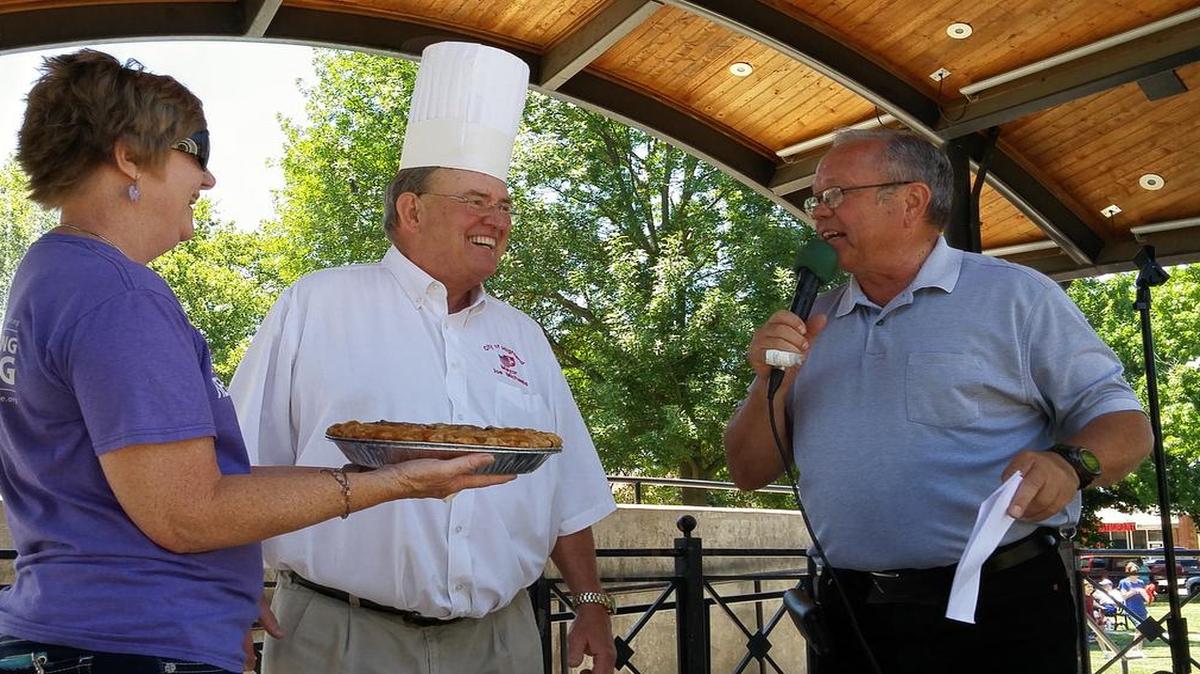 Highland Mayor Joe Michaelis talks to auctioneer Virgil Straeter about his blackberry pie during the Oldies but Goodies Relay for Life Team Celebrity Pie Auction on Friday. Holding up the pie is Gay Bentlage of the Highland News Leader.