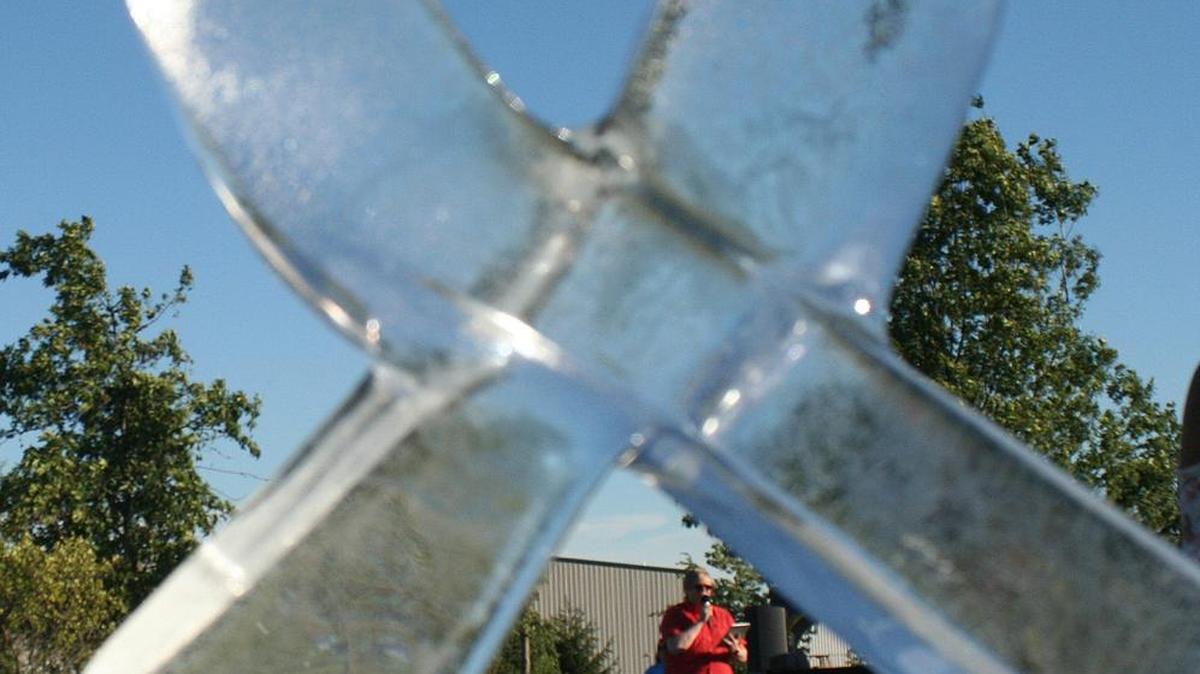 2017 Relay for Life emcee Brian Knobloch is framed by an ice sculpture of a cancer awareness ribbon during the opening ceremonies for Highland’s Relay event on last year at Glik Park. This year's Relay will be at Highland Hope UMC.