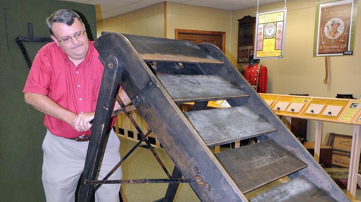 John Goldsmith, DeMoulin Museum curator, demonstrates the museum’s latest collection piece, “The Sliding Stairs,” manufactured by DeMoulin Bros. & Co. during its fraternal period in the early 1900s.