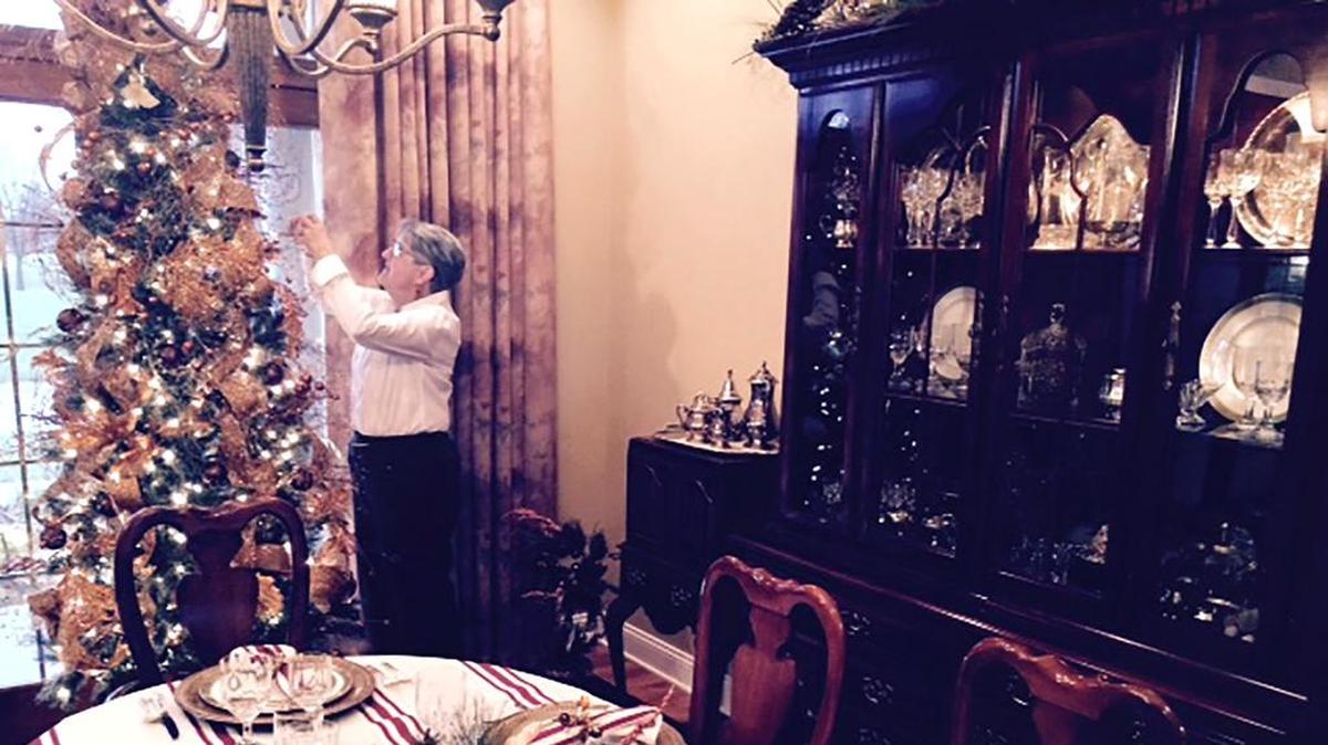 Jay and Cathy Boulanger’s home will be on the Highland IFBW’s Twilight Holiday Home Tour Saturday, Dec. 2. Cathy is shown putting the finishing touches on the Christmas tree in their dining room, one more than a dozen Christmas trees in their home. The dining table is all set and ready for Christmas dinner.