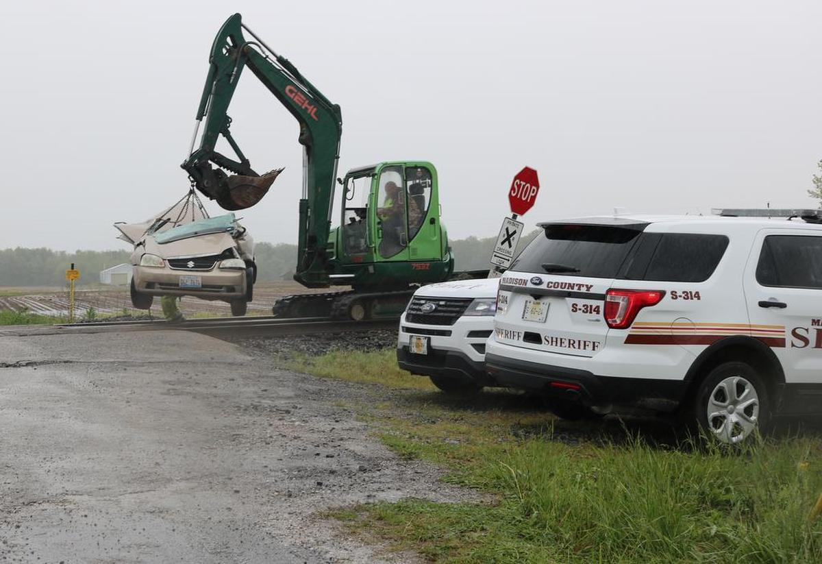 A four-door golden Suzuki sedan is taken off of the railroad tracks located at the crossing on Farmlane Road near Veterans Honor Parkway in Highland. The car was involved in a collision with a train Wednesday morning. See a gallery of photographs and a video at bnd.com.