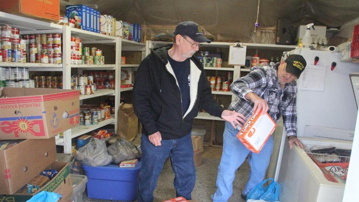 
Charlie Martin hands Dave Tune a frozen pizza Monday at the Bread of Life food pantry in Hamel.
