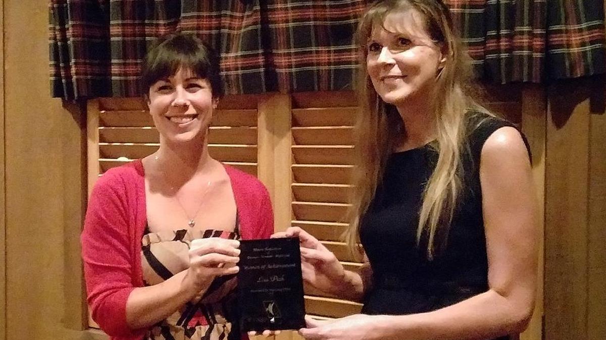 Highland IFBW president Jennifer Libbra, left, presents the club’s Woman of Achievement award to Highland Assistant City Manager Lisa Peck.