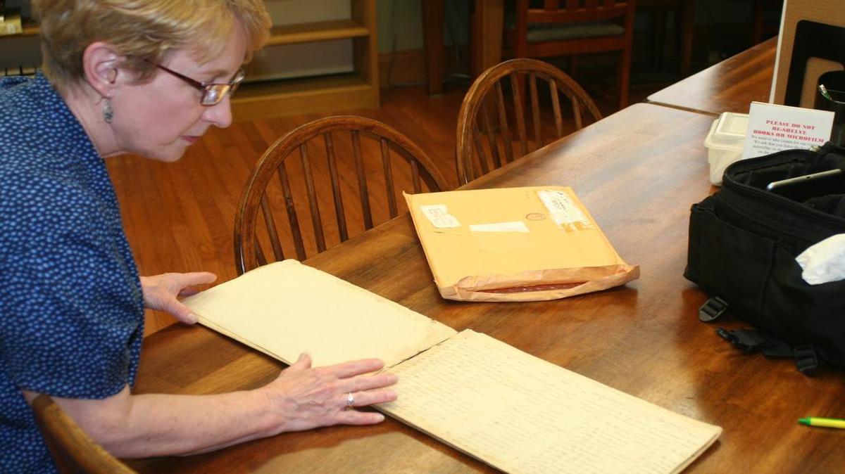 Kathy Kessels, executive secretary of the Looking Glass Genealogy Group, looks at a book containing the names of Highland’s Grand Army of the Republic, fraternal organization of Civil War veterans. The book is in the genealogy room at Latzer Library in Highland.