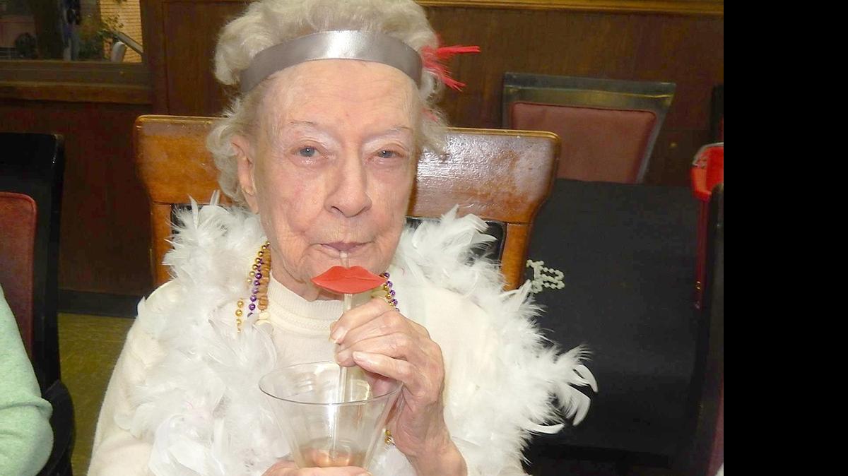 
Loretta Noll enjoys her “bathtub gin” at the “Roaring ’20s” party at Alhambra Care Center. Residents had a fun time during their “Roaring ’20s” party. Flapper-style dress and a speak easy décor increased the mood. Mark Phelps played ’20s-style ragtime tunes on the piano, and those that could, enjoyed a little soft shoe-style dance. Bathtub gin (donated Moscato wine) made the party fun for all.

