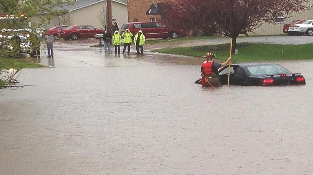Highland Fire Department Lt. Mike Rose wades into flood waters on Woodcrest Drive on April 18, 2013 to rescue a motorist who had driven into the water. That day, 4.4 inches of rain fell in Highland, causing flash flooding. The Federal Emergency Management Agency (FEMA) is currently in the process of updating its flood risk map for the Highland area.