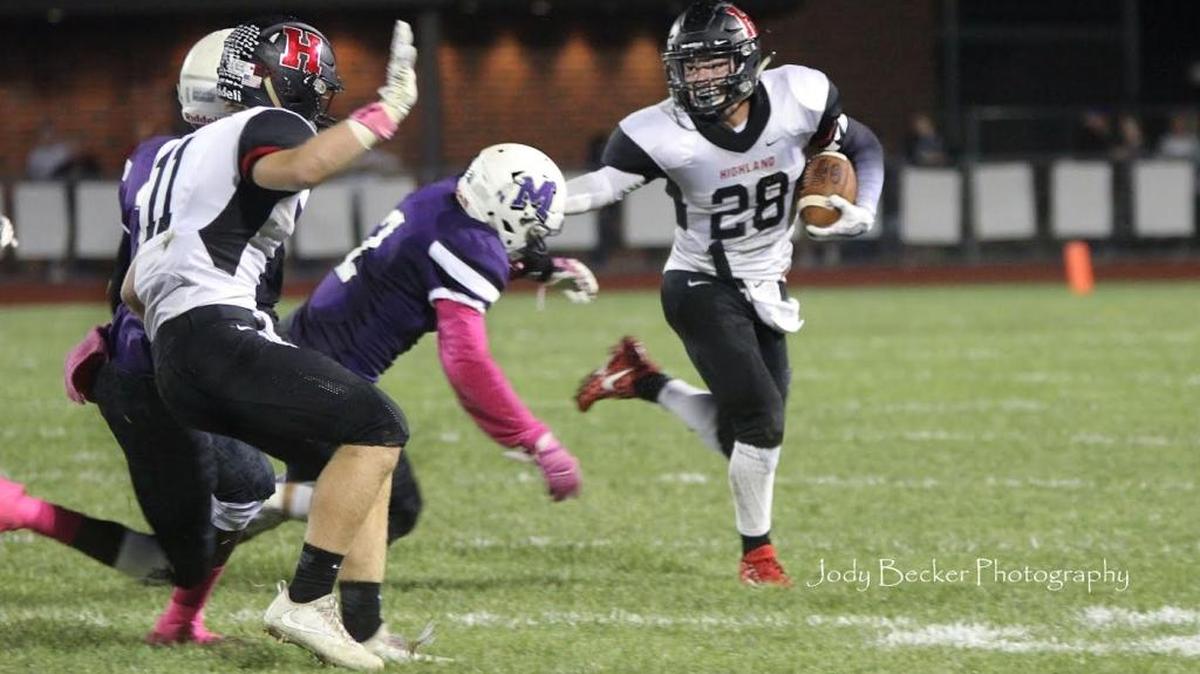 Highland junior running back Brady Feldmann stiff arms a Mascoutah defender during the Bulldogs’ 55-22 rout of the host Indians Friday night.