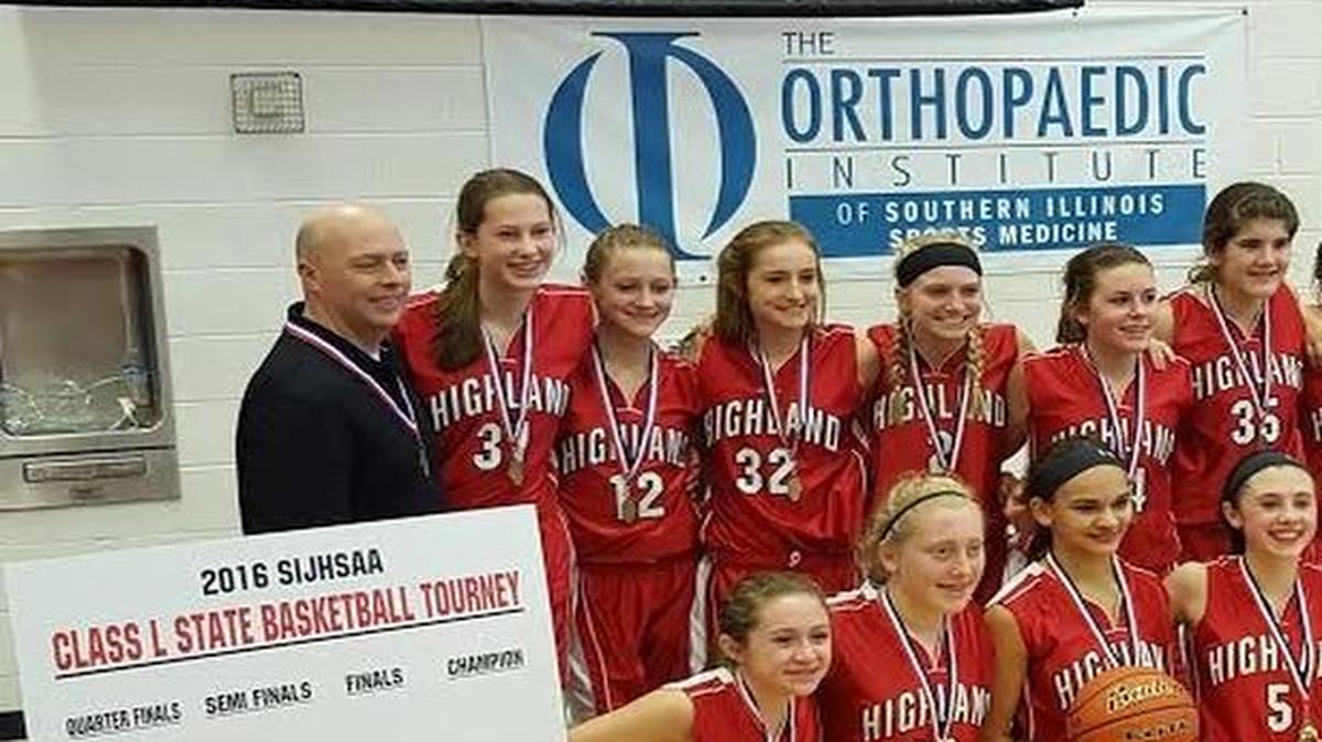 The Highland Middle School eighth grade girls basketball team pose with the championship trophy after beating Collinsville 47-38 in the finals of the SIJHSAA Class L State Championship Saturday at Rend Lake College. The Lady Bullpups consist of, front row from left to right, Lia Basden, Delaina Sigman, Megan Kronk, Ellie Brown, Meridith Kleinmann, Kersten Taylor; back row, head coach Glen Sharpmack, Madison Clark, Ashlen Klucker, Madison Fenton, Sam Hengehold, Kate Feldmann, Taylor Flemming, Galena Stewart, Emmalee Michaels and assistant coach Donna Bennett.