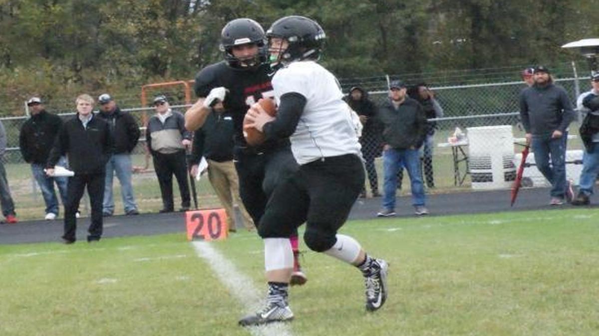 Decatur Eisenhower quarterback junior Cayleb Dehority gets set to try and throw a pass as Highland senior linebacker Sam Teipe closes in during the first half of the Panthers’ shocking 39-29 win at HHS Saturday afternoon.
