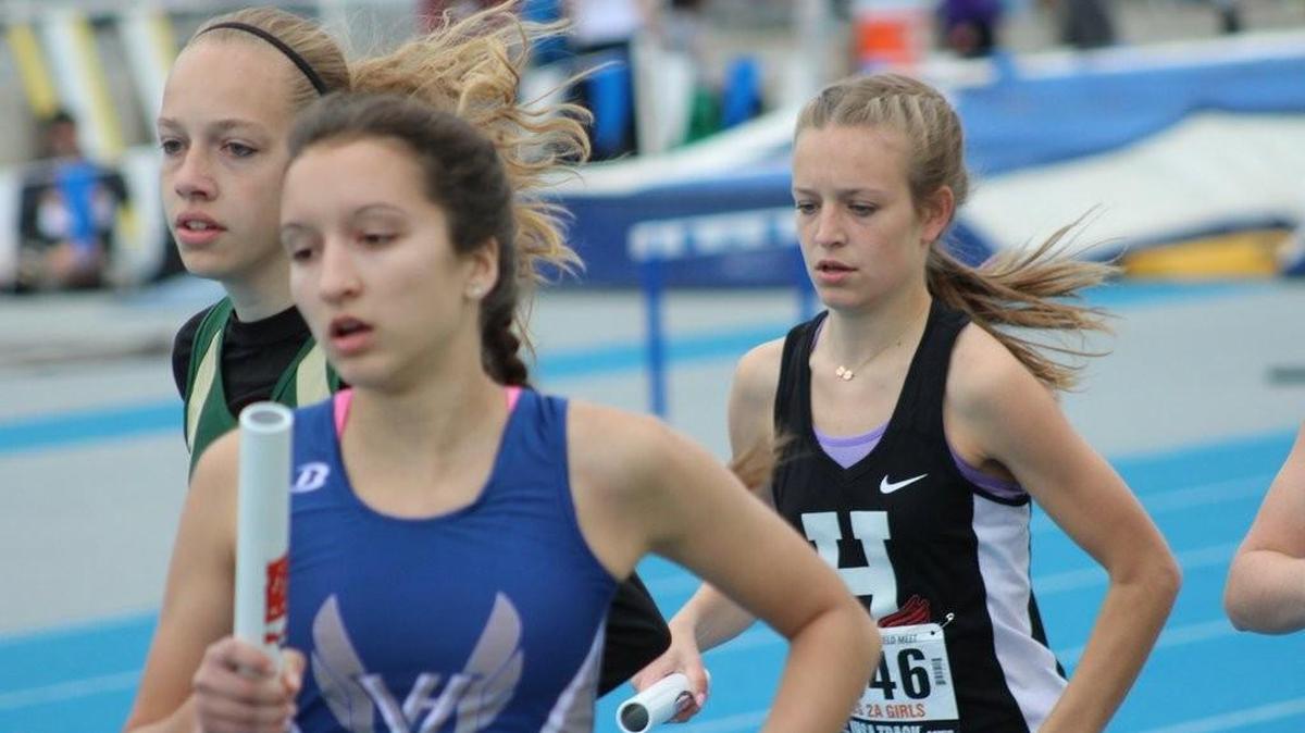 Highland senior Allison Zobrist, right, runs the second leg of the 4 x 800-meter relay team at the IHSA Class 2A Girls State Track and Field Meet at Eastern Illinois University.