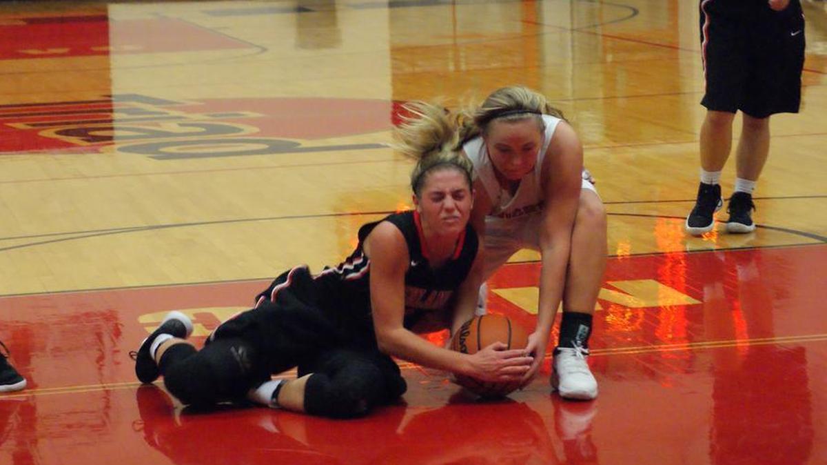 Highland senior Rece Portell, left, wrestles for the ball with Triad senior Brooke Rensburger during the second quarter of the Bulldogs’ 65-30 win over the host Knights Thursday.