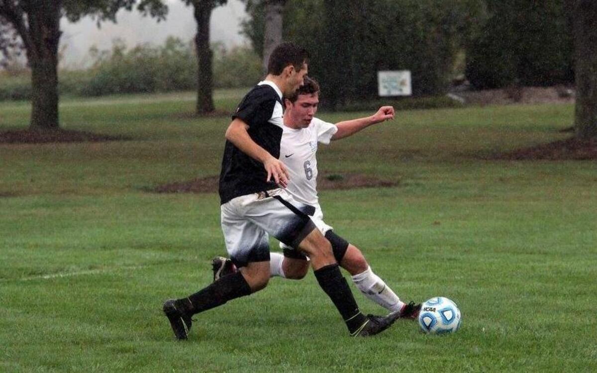 Highland senior forward Lucas Ammann works with the ball while being closely guarded by Parkway West’s John Crowder during the Bulldogs’ 1-0 victory in the rain Saturday morning at Glik Park.