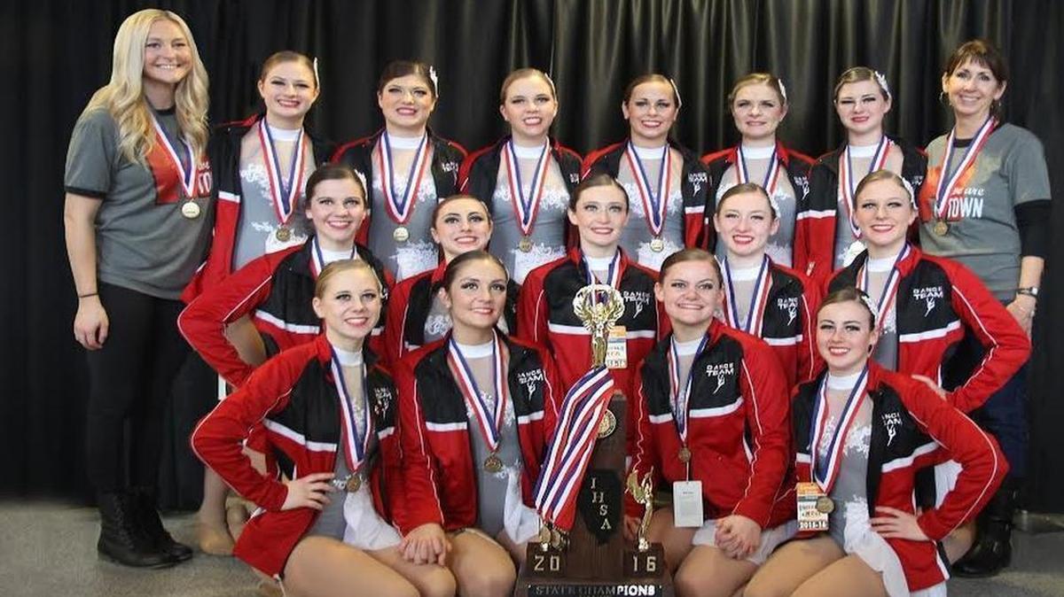 The members of the Highland High School dance team don their medals and pose with the championship trophy after being named the 1A state champions at the IHSA Competitive Dance State Finals Saturday at U.S. Cellular Coliseum in Bloomington. The team features, first row from left to right, Leslie Drueke, Kelsey Lane, McKenzie Rosen, Lexy Hagler; second row, Reagan Thornton, Raven Miranda, Ally Becker, Abigail Rogier, Hannah Luitjohan; third row, coach Emily Wellen, Brooke Wilson, Kayla Davis, Claire Pabst, Katie Etter, Paige Foster, Olivia Genteman and coach Michelle Deets.