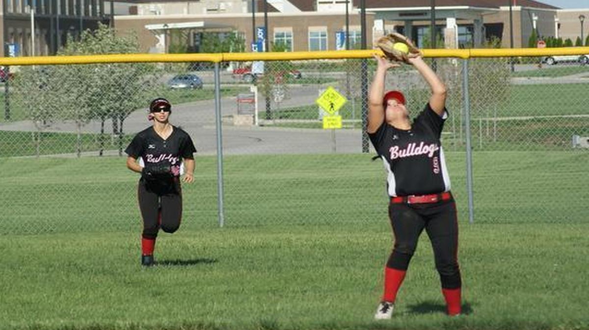 Highland junior second baseman Peyton Holzinger catches a fly ball while fellow junior Aubrey Hacke looks on from right field during the Lady Bulldogs’ 9-6 loss to Teutopolis last Thursday at HHS.