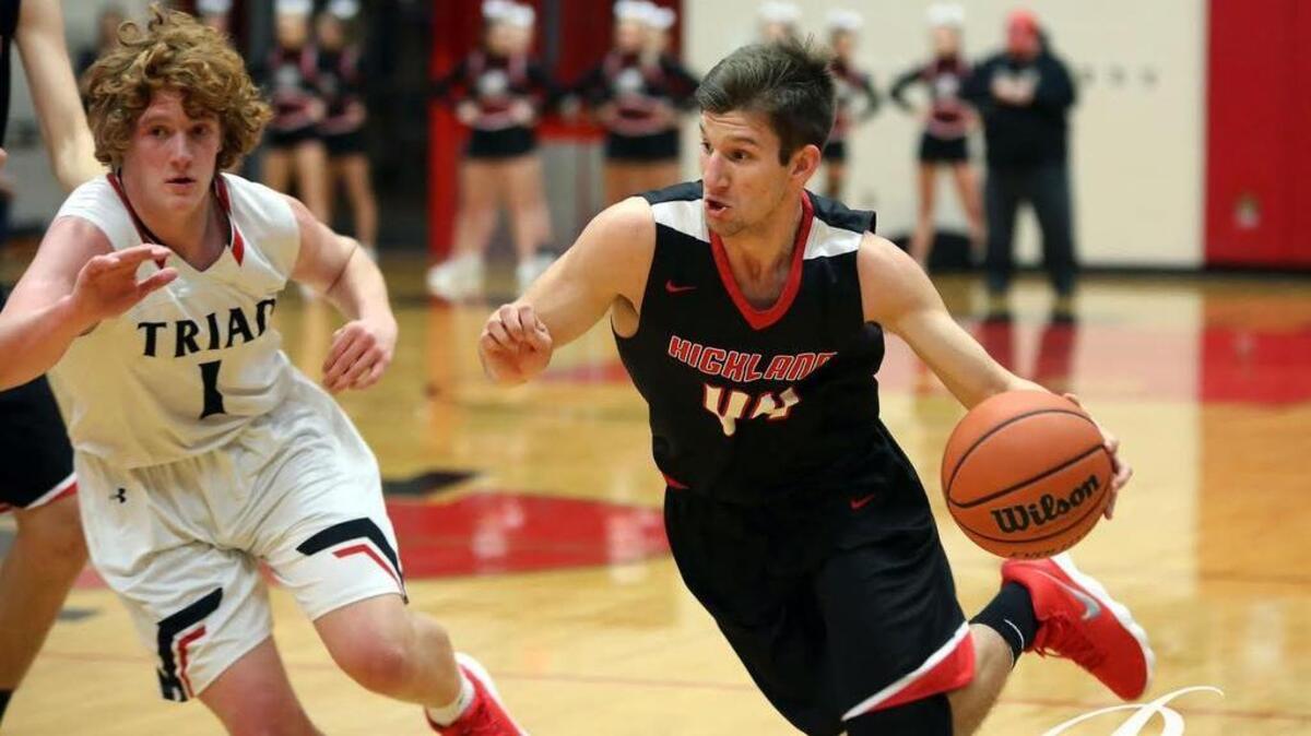 Highland senior Stephen Schniers looks to drive to the basket by Triad senior Beau Barbour during the Bulldogs’ 44-41 victory at Triad Friday night.