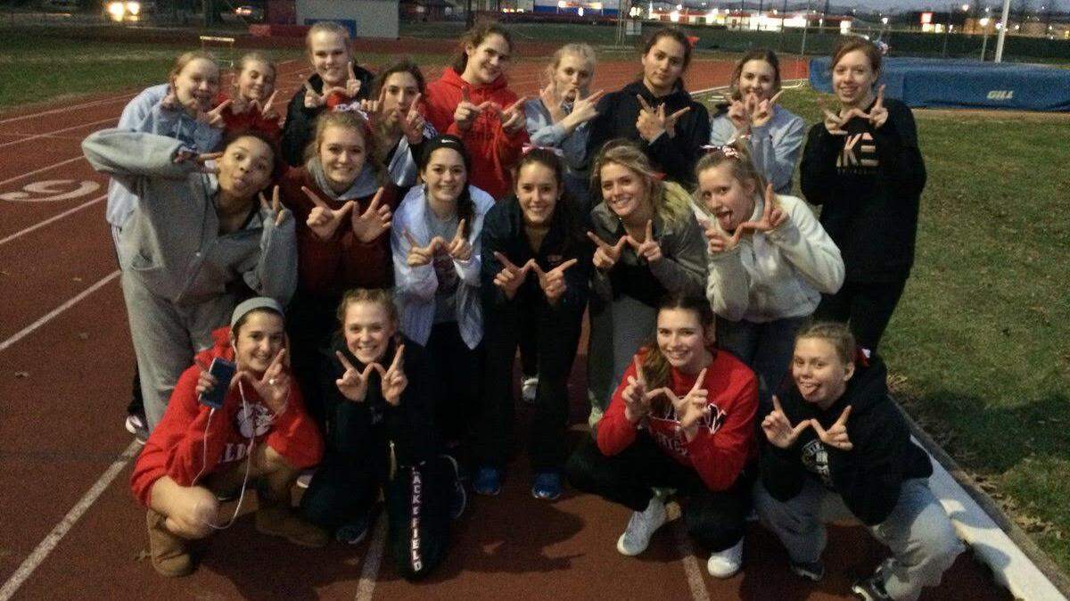 The members of the Highland High School girls track and field team hold up a W after the Lady Bulldogs dominated their outdoor season opener at Granite City, 94-42, on Thursday at Granite City High School.