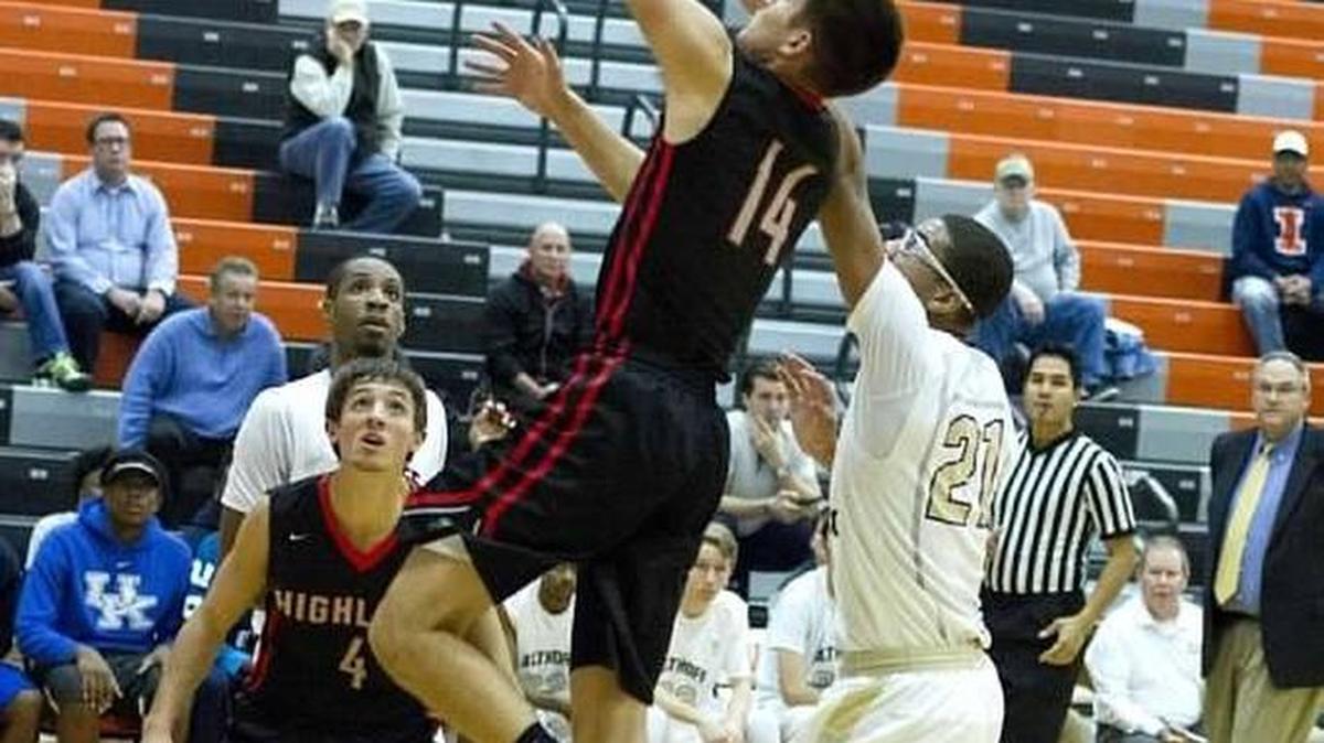 Highland sophomore Stephen Schniers goes in for a left-handed layup over Althoff’s Dante Ray (21) in the Bulldogs’ 66-51 victory over the Crusaders on Tuesday of last week at the Battling Bulldogs Thanksgiving Tournament at Waterloo High School.