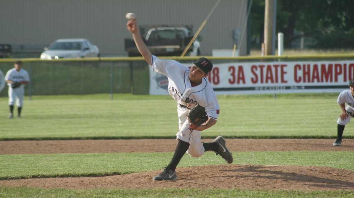Highland senior pitcher Griffin Welz delivers a pitch during the Bulldogs’ 9-1 win over visiting Alton Marquette Monday in a quarterfinal of the IHSA Class 3A Highland Regional.