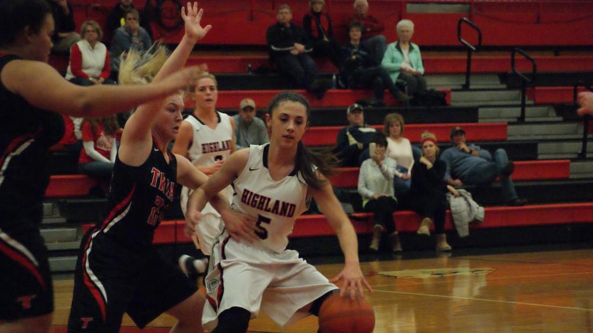 Highland sophomore guard Ellie Brown, shown working through traffic against Triad junior Jordan Wilson (24) and Krista Cochran, buried five 3-pointers and topped all scorers with 18 points in the Lady Bulldogs’ 72-39 rout of the visiting Knights on Thursday.