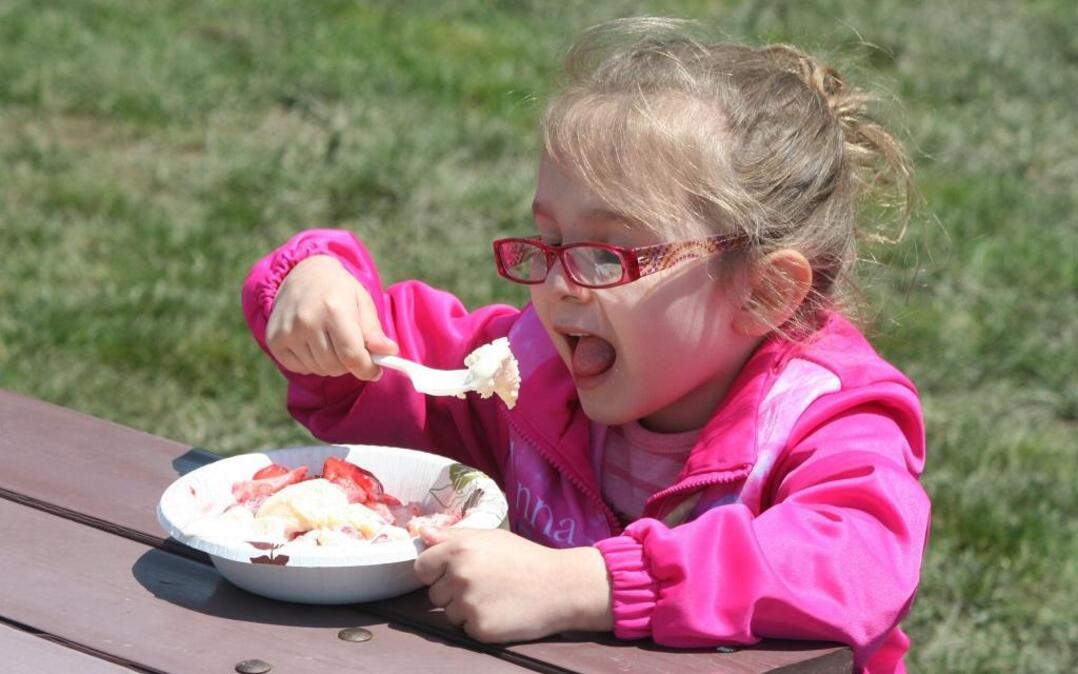 A girl enjoys strawberry shortcake at last year’s St. Jacob Strawberry Festival.