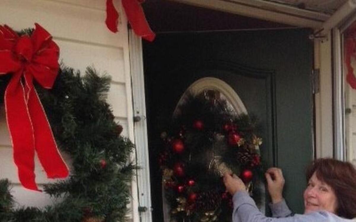 Janet Nicolaides hangs a wreath on her front door in preparation for the Twilight Holiday Homes Tour Saturday. The Nicolaides home is known for its outdoor lights and decorations for holidays throughout the year and especially at Christmas time. Inside, family and holiday traditions are reflected throughout creating an old time Christmas atmosphere.