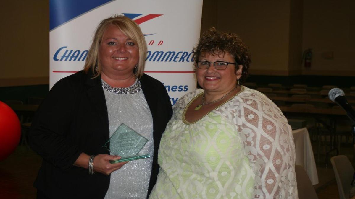 Highland Chamber of Commerce President Tricia Buehne (left) accepts the Bill Pierce Chamber Member of the Year Award from Judy Neier (right).