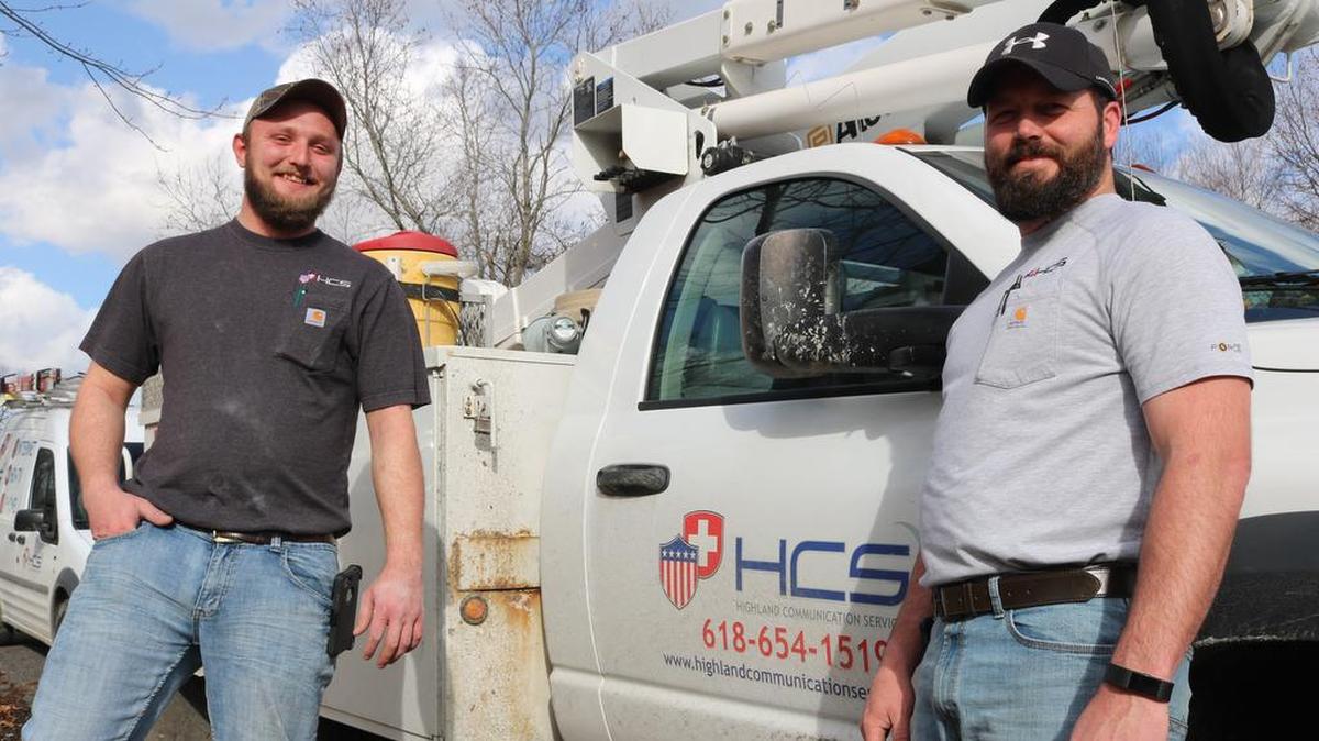 Joe Hulliung, left, and Clayton Moore, right, service technicians with Highland Communication Services, stand in near a company truck. HCS was recently ranked 5th out of the 40 community owned fiber to premises enterprises in the nation in for providing the most savings in basic broadband services as compared to its private competitors, in a study from Harvard University that was published in January.