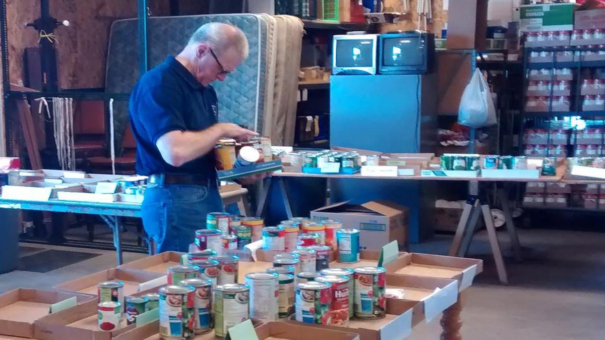 Steve Thiems, a regular volunteer at the Highland Area Christian Service Ministry food pantry, sorts food collected by Highland letter carriers May 14.