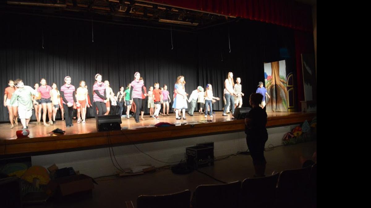 
The cast of Alice in Wonderland Jr. rehearses their final dance and director Gentry Nessel looks on.
