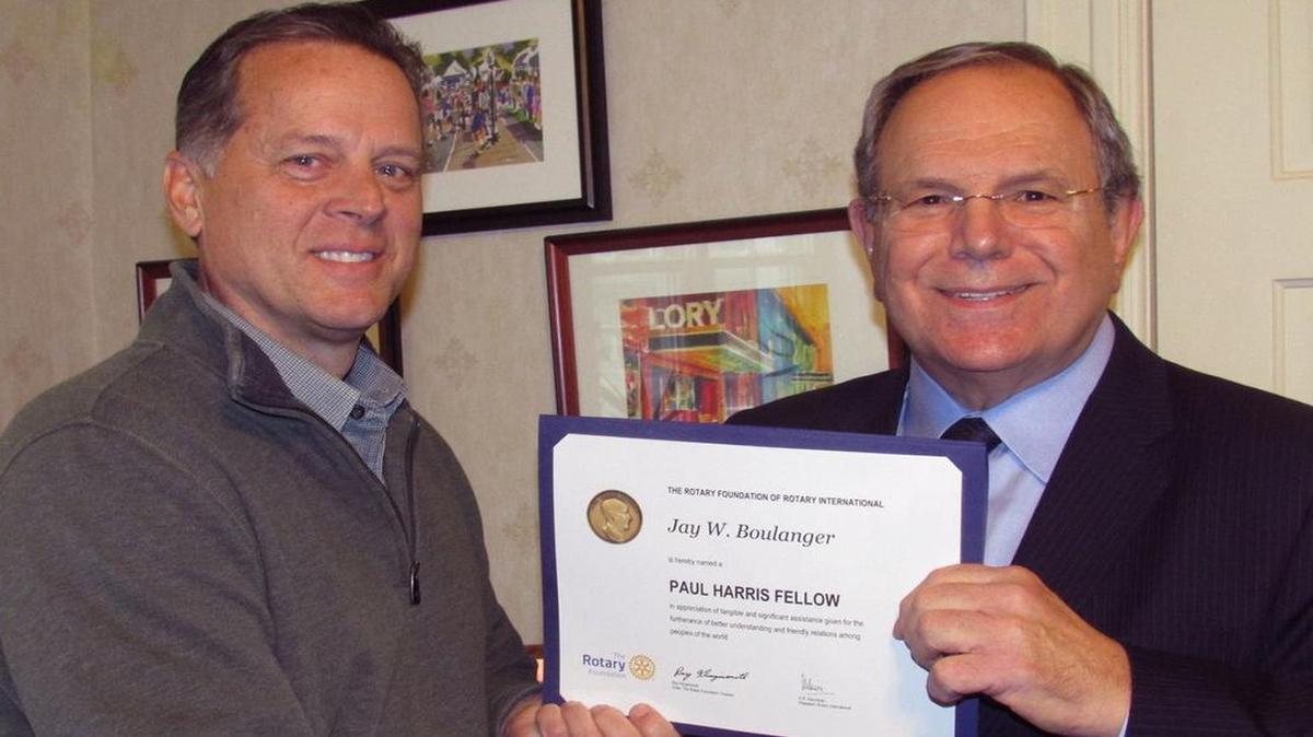 Highland Rotary Club president Bob Luitjohan, left stands with Jay Boulanger and his newly awarded Paul Harris Fellow award certificate.