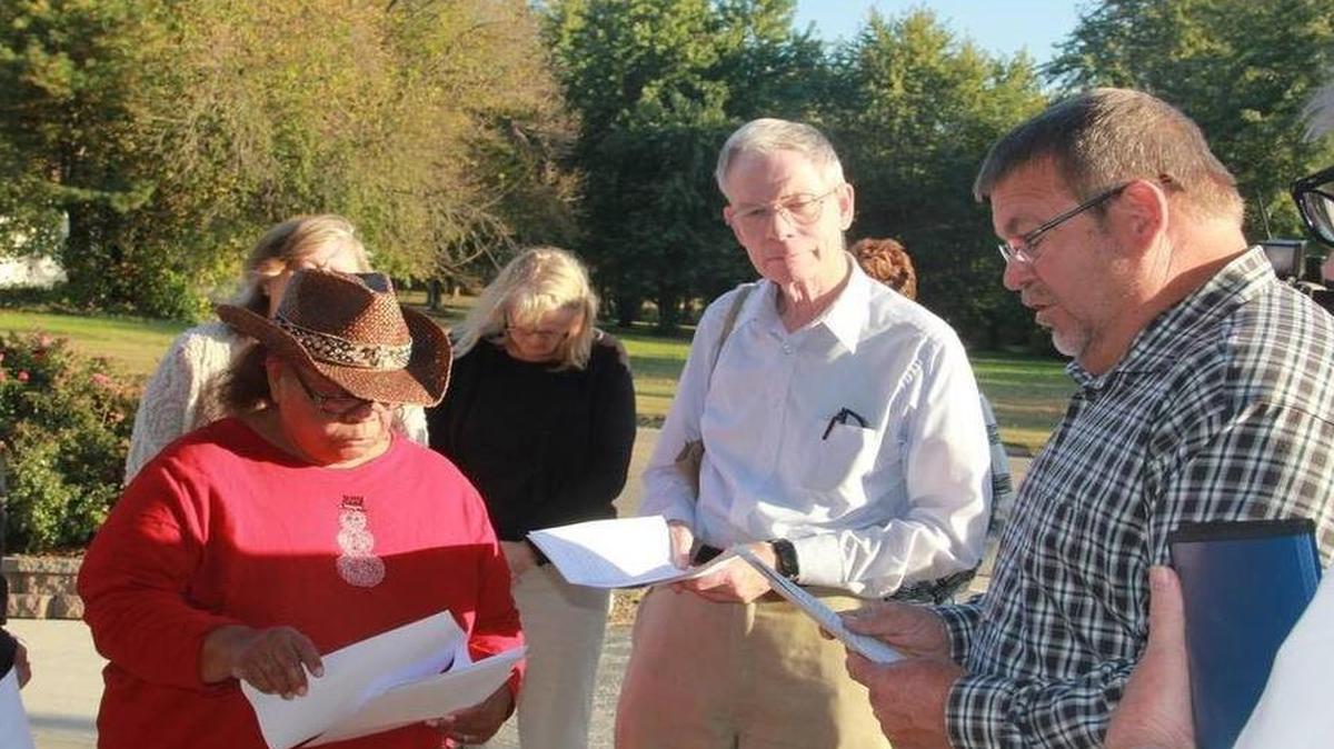 State Rep. Charlie Meier offers a prayer at a prayer vigil in front of his office in Highland on Oct. 19. He was joined by United Congregations of Metro-East president Norma Patterson, Mike Berens, a leader with UCM and Mike Schuette, board chair of Catholic Charities of Southern Illinois and about 22 others who attended the vigil. UCM was seeking to overturn new rules put in place by Gov. Bruce Rauner regarding qualifications for childcare assistance.