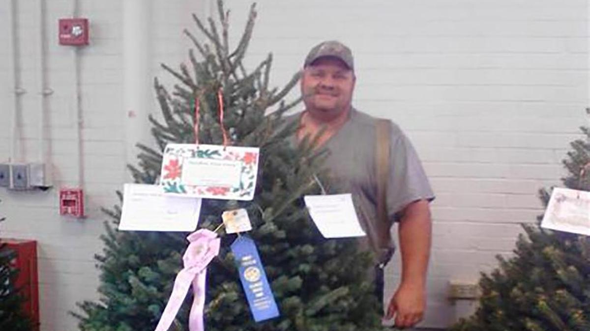 
David Daniken stands beside the 2015 Illinois State Fair reserve champion Christmas tree from Daniken Tree Farm.


