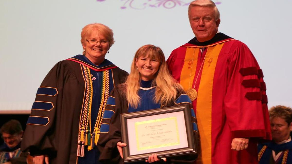 Exemplary Teaching Award Dr. Michele “Mickey” Schutzenhofer of St. Jacob won the 2016 UMC Exemplary Teaching Award at McKendree University. She is standing between Dr. Christine Bahr, provost, and Dr. James Dennis, university president.