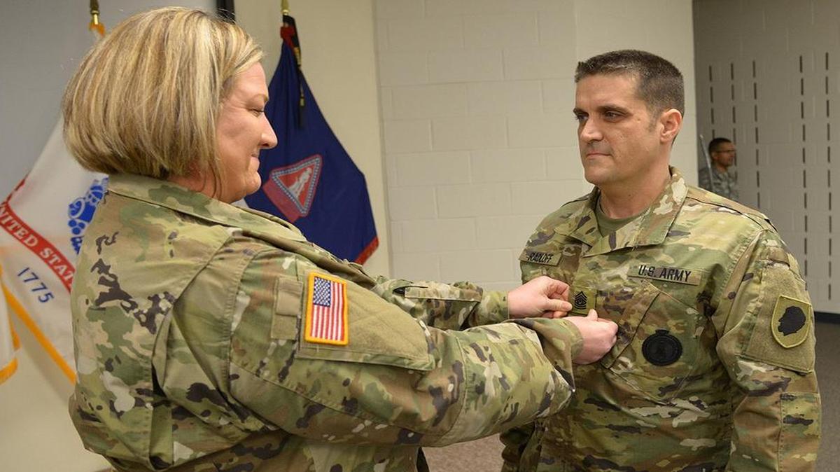 Sgt. 1st Class Christine Radloff places command sergeant major rank on her husband, Stephen W. Radloff of Troy, during a promotion ceremony at Camp Lincoln in Springfield, Ill., Jan. 30. Both soldiers are with the Recruiting and Retention Battalion in Springfield.