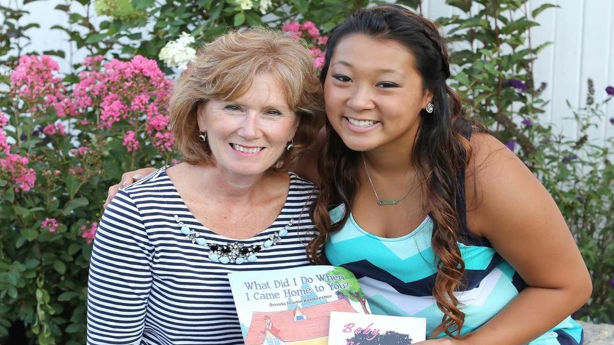 Brenda Kohlbrecher poses with her daughter, Makala, and her two books.